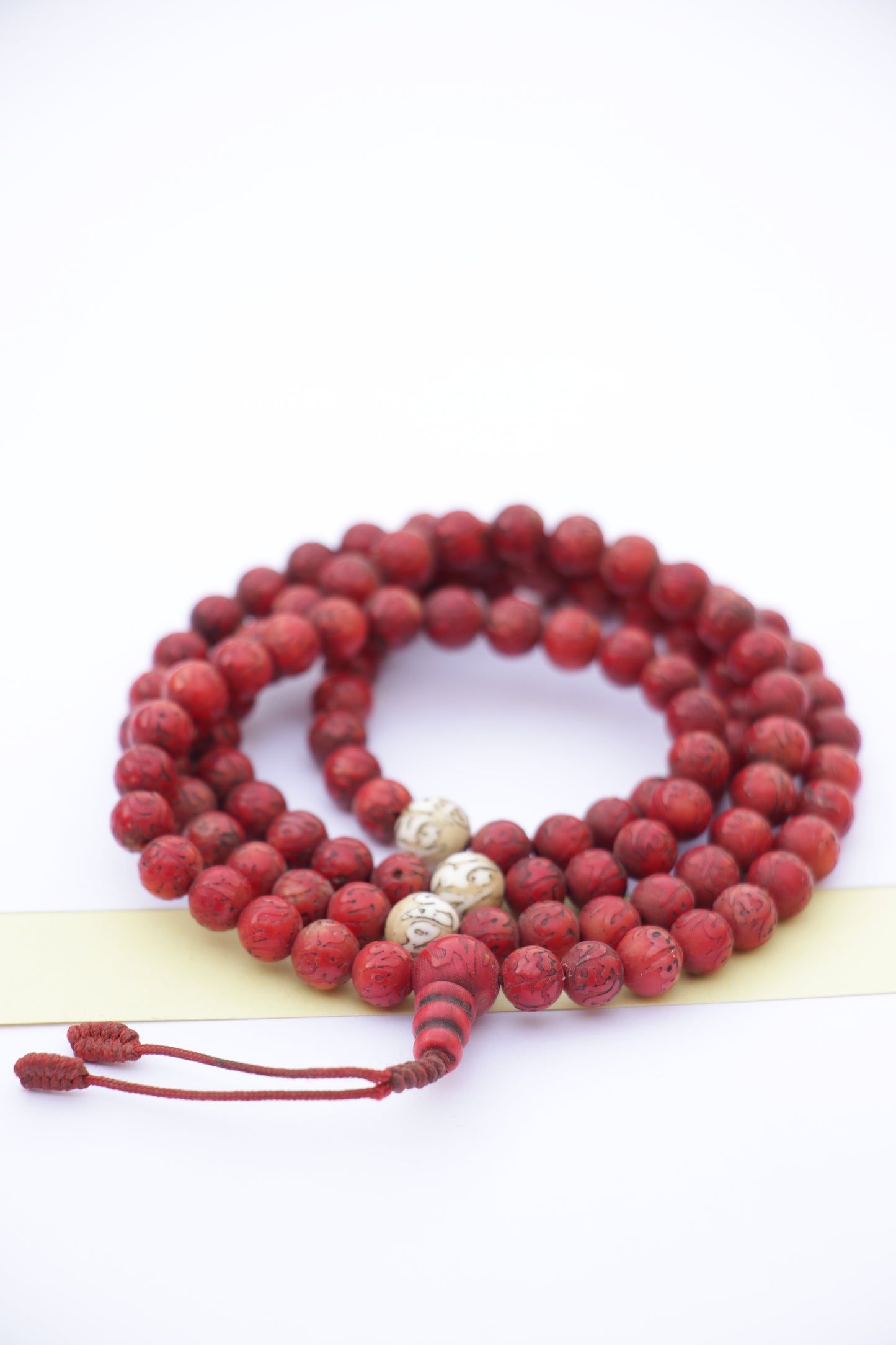 Coral mala with engraved Tibetan Mantra
